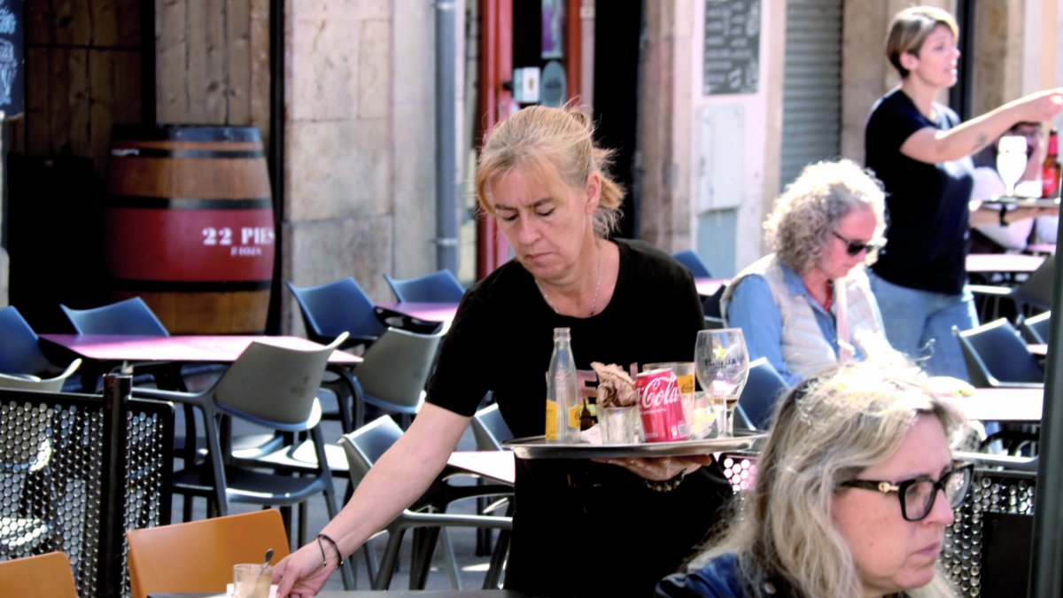 Una cambrera treballant en una terrassa de bar.