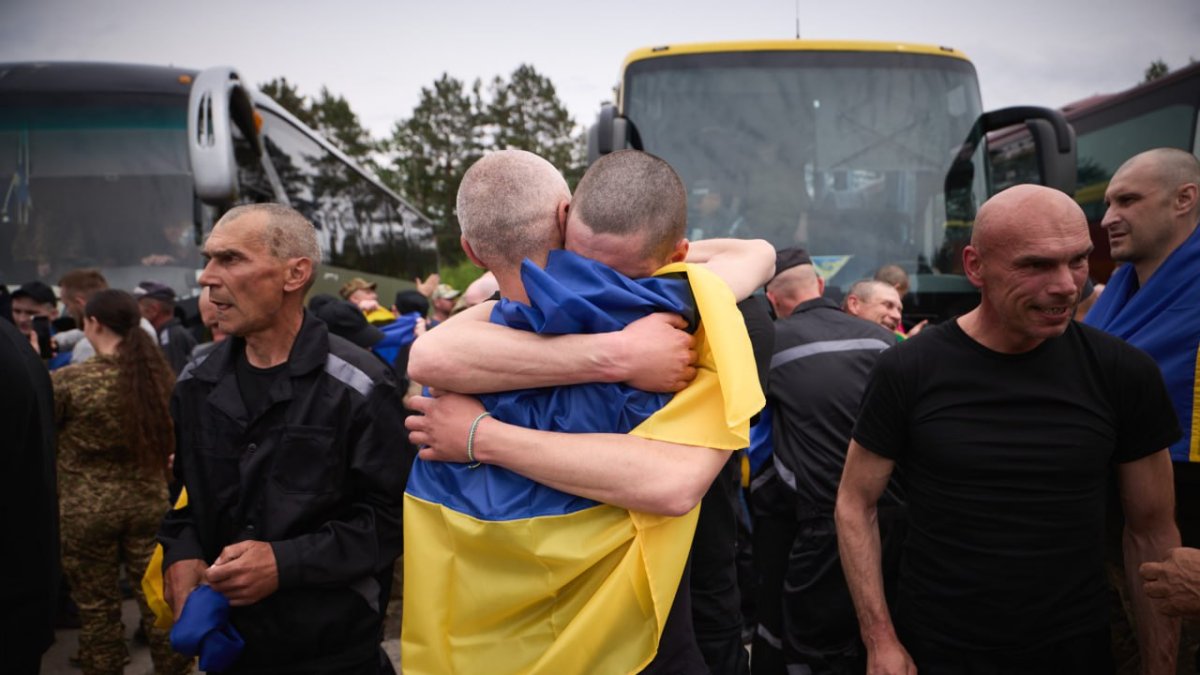 Presoners ucraïnesos intercanviats arran de l'acord entre Rússia i Ucraïna s'abracen al ser alliberats, portant a sobre una bandera ucraïnesa