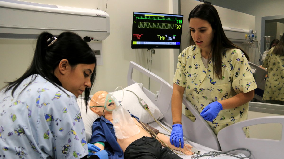 Dos enfermeras pediátricas hacen pràciques en las aulas de simulación de la URV.