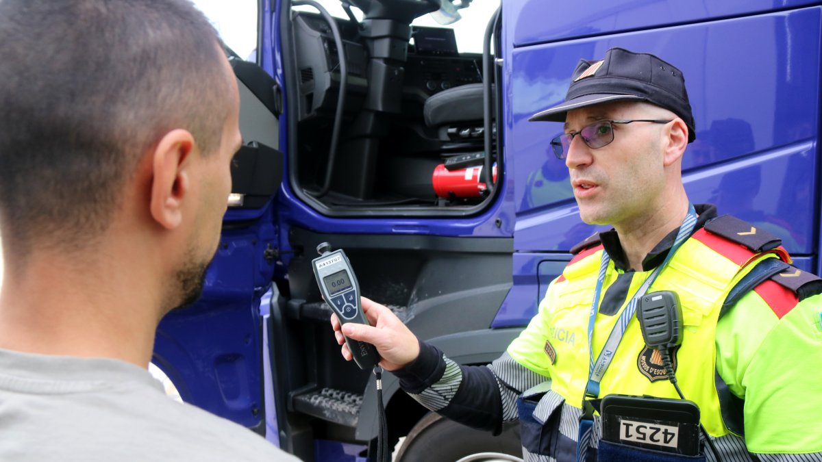 Un agente de los Mossos muestra el alcoholímetro marcando cero después de una prueba a un camionero al AP-7, a la altura de Salou.