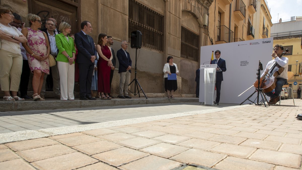 El adoquín en homenaje del antifascista deportado a los campos nazis y, en el fondo, el presidente de la Generalitat, Salvador Illa.
