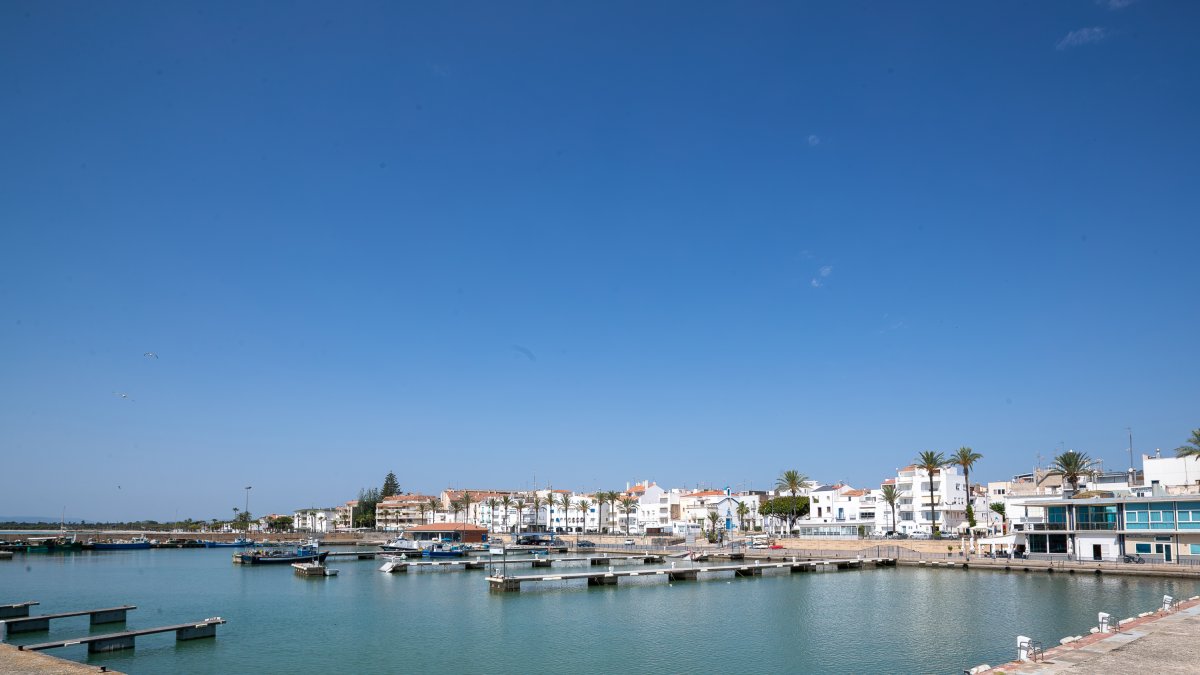 La dársena vacía del puerto de las Cases d'Alcanar, con el núcleo urbano en el fondo
