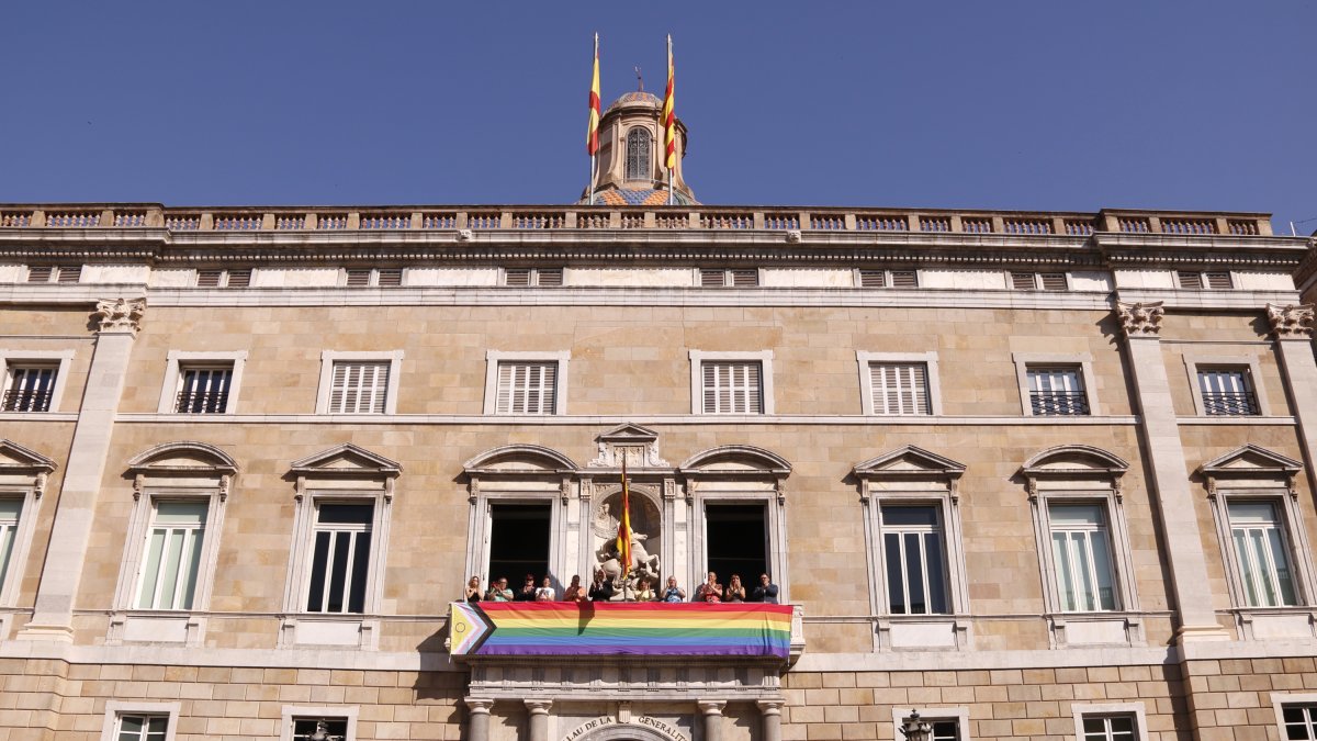 El Palau de la Generalitat amb una bandera LGBTI desplegada al balcó per commemorar el Dia Internacional per a l'Alliberament LGBTI+