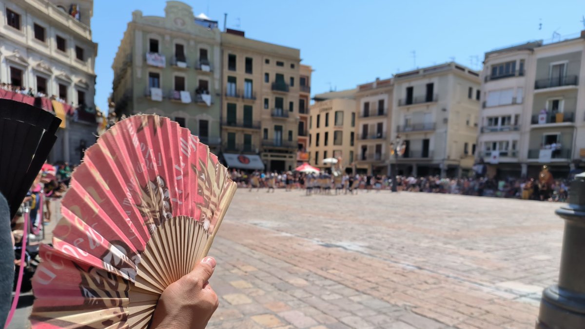 Una persona abanicándose en la plaza del Mercado de Reus.