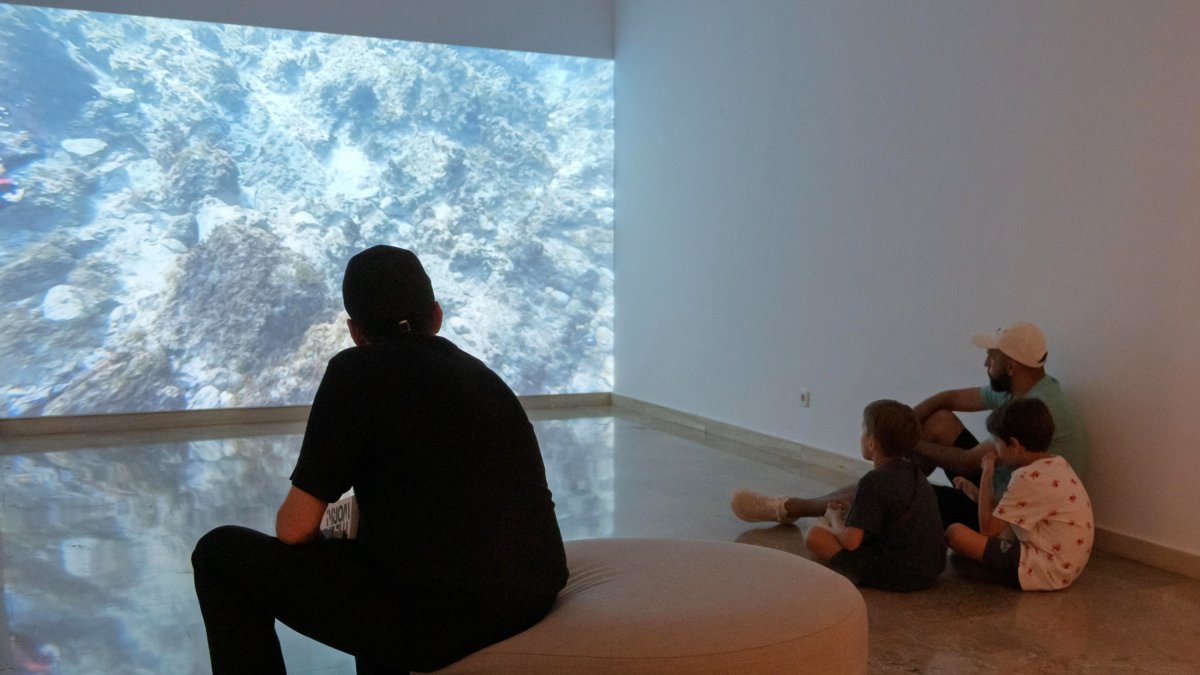 Espectadores mirando la obra ganadora de la BADt 2025 en el MAMT