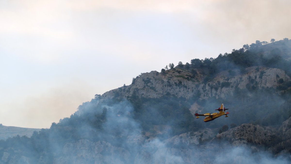 Una avioneta sobvola la zona cremada del racó de l'Augueró a Paüls