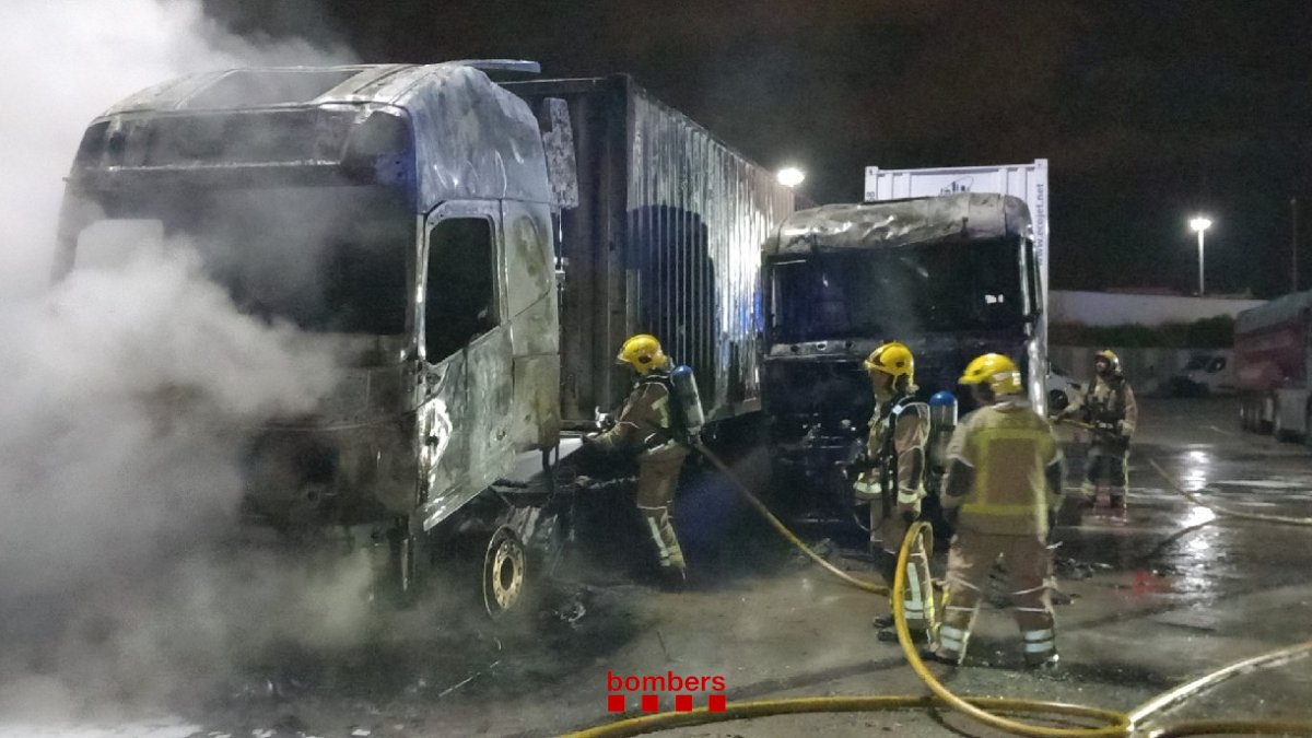 Els bombers duent a terme les tasques d'extinció dels dos camions.