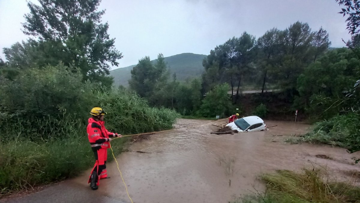 Los Bomberos retirando un coche que se ha llevado el agua al río Cardener, en Súria