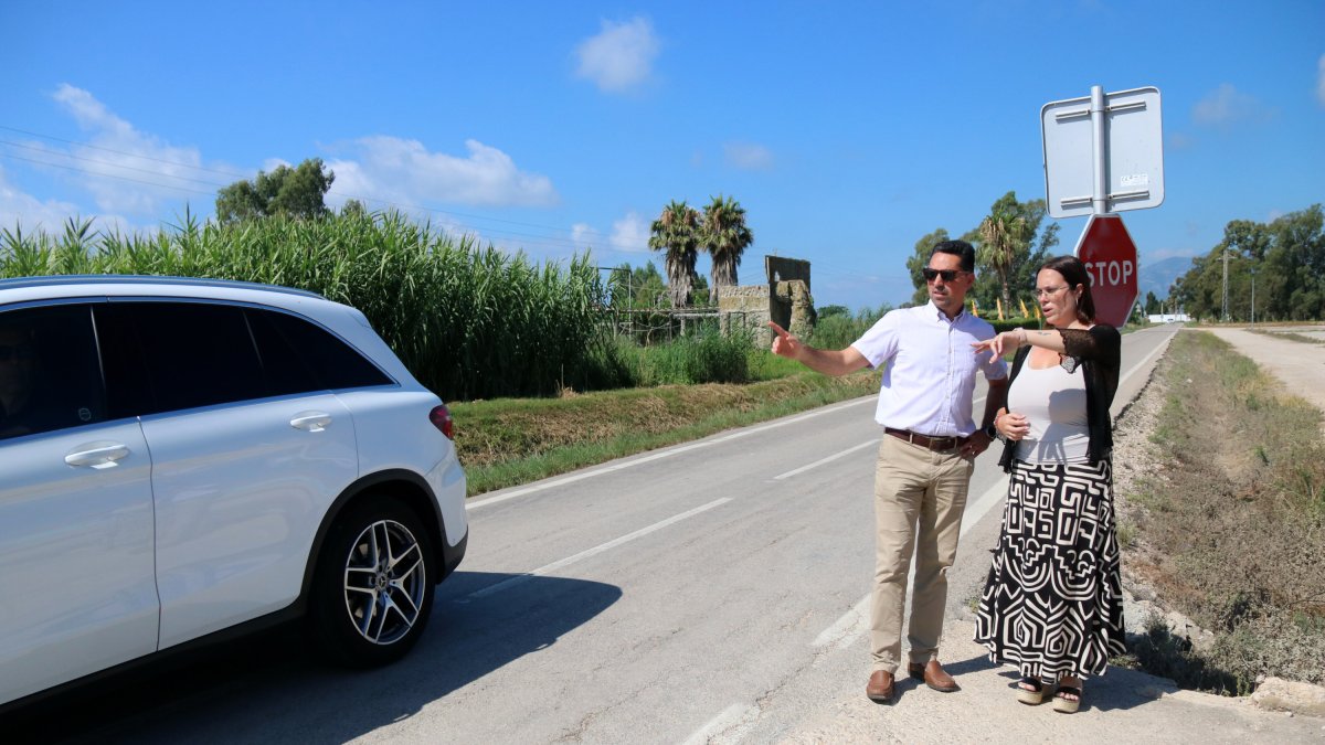 Un coche pasar por la carretera T-2021 durante la visita de la diputada provincial Iris Castell y un responsable técnico del área de Infraestructuras del Territorio de la Diputació de Tarragona, en Poble Nou del Delta.