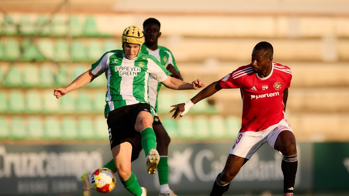 El davanter del Nàstic de Tarragona Cedric Omoigui pressionant al central del Betis Deportivo Félix Garreta.