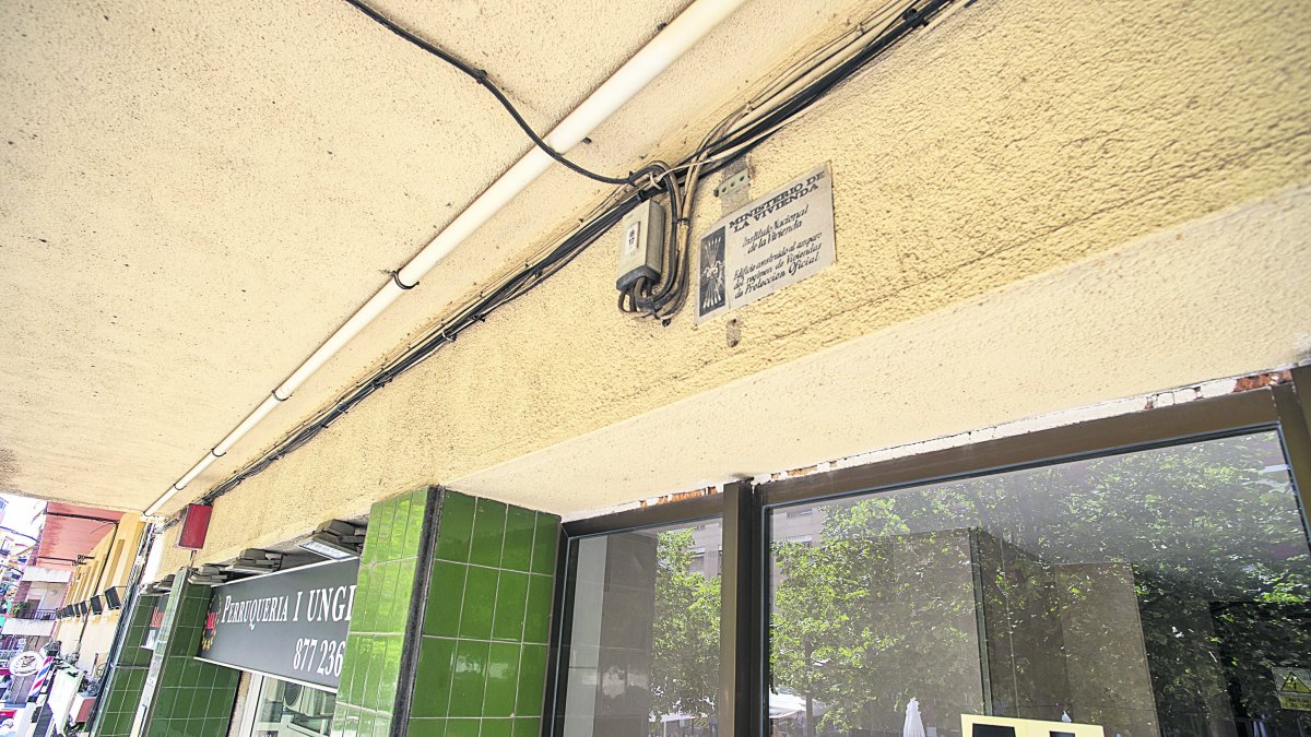 Edifici a l’avinguda del Carrilet que conserva la placa de l’Instituto Nacional de la Vivienda, en la part superior del portal.