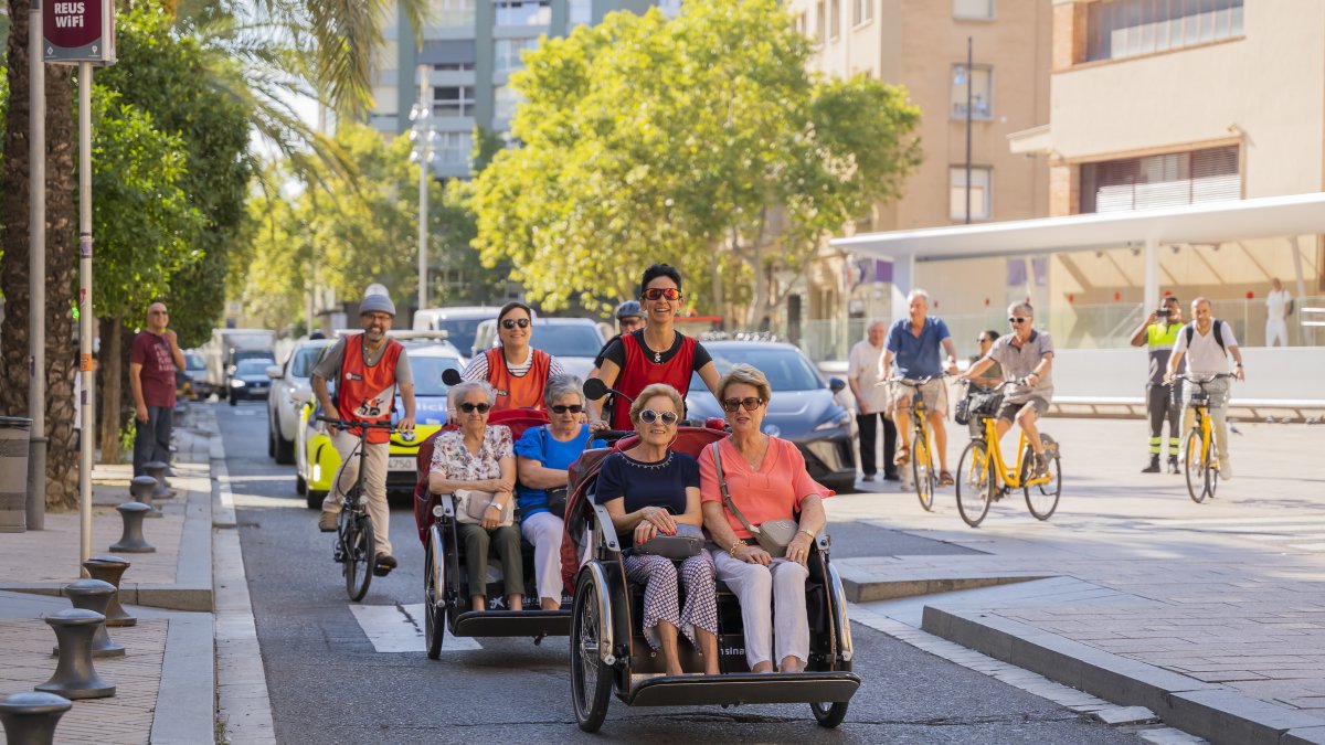 Diverses persones gaudint del passeig amb tricicle.