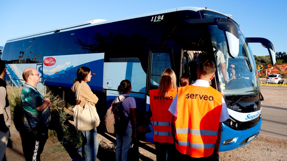 Diverses persones fan cua per pujar a l'autobús habilitat per Renfe entre Cunit i Barcelona
