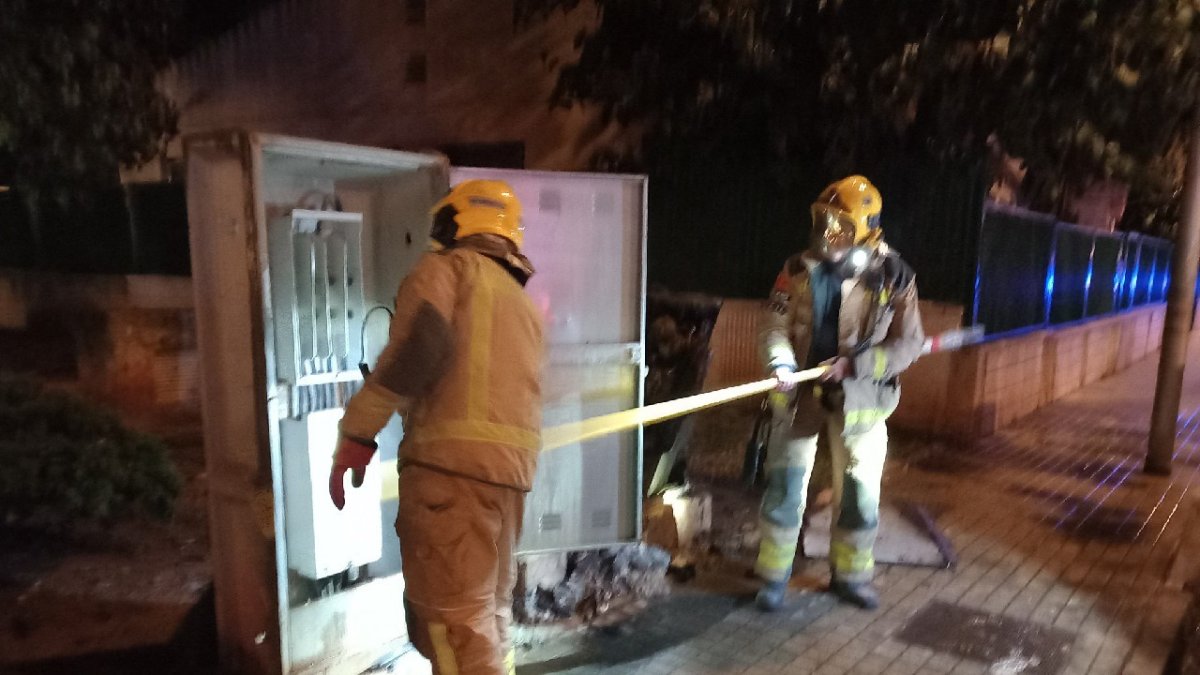 Els bombers treballant en l'incendi que ha afectat una caixa de distribució elèctrica de l'enllumenat públic.