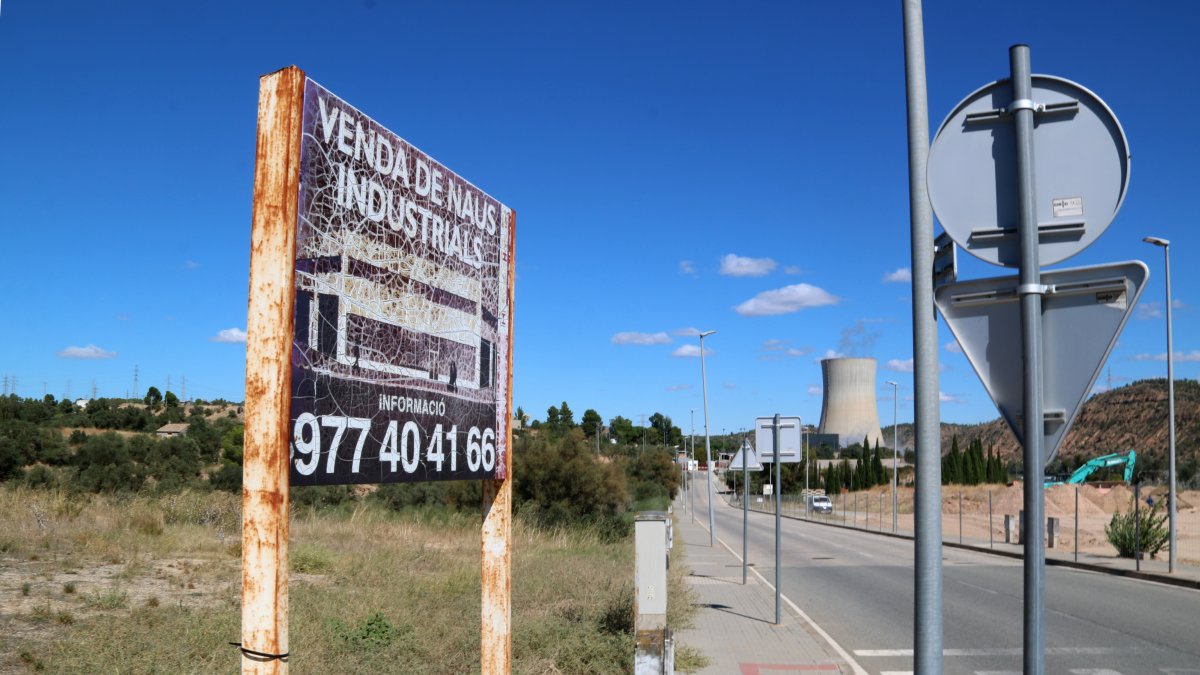 Antic cartell de venda de naus industrials davant del tancat on es construeixen les noves infraestructures