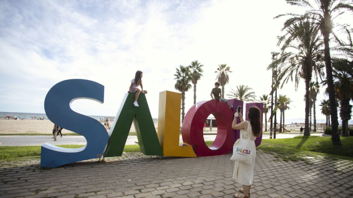 Una turista fent una foto a les lletres de Salou