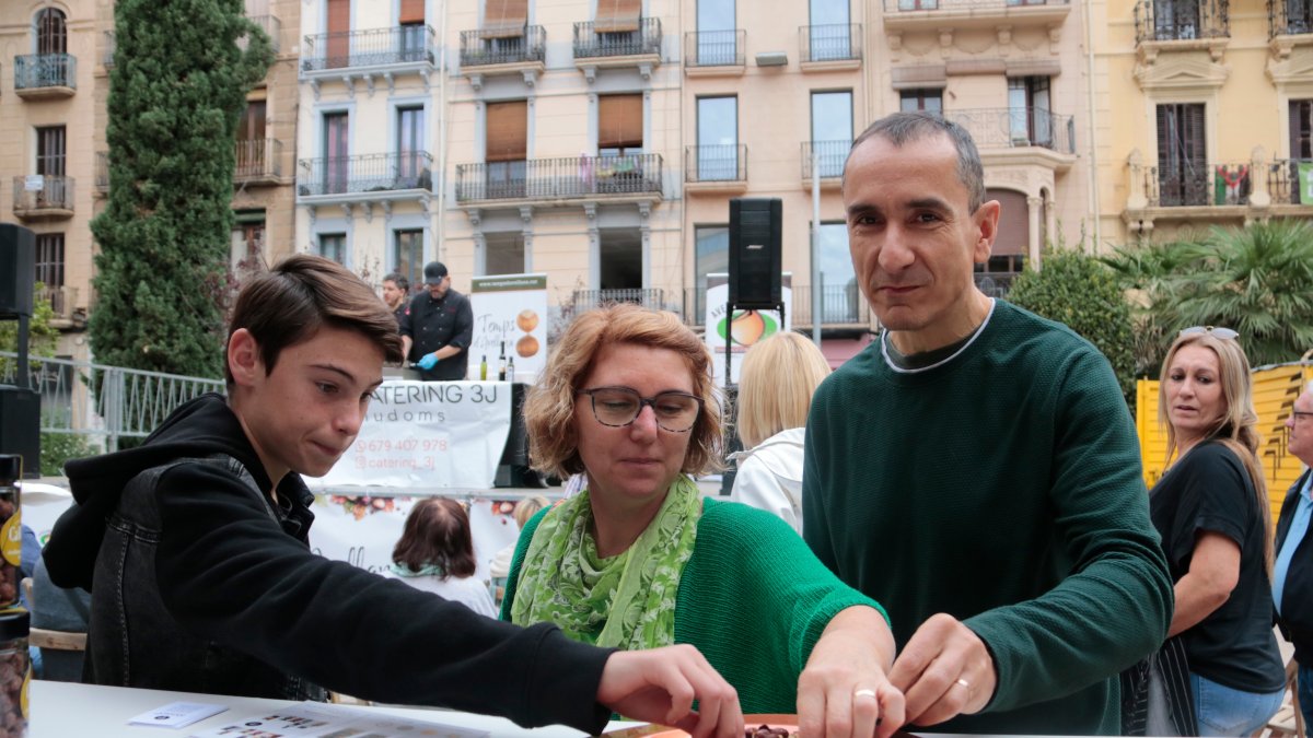 Una família tasta avellanes durant la 4a festa de l'avellana de Reus