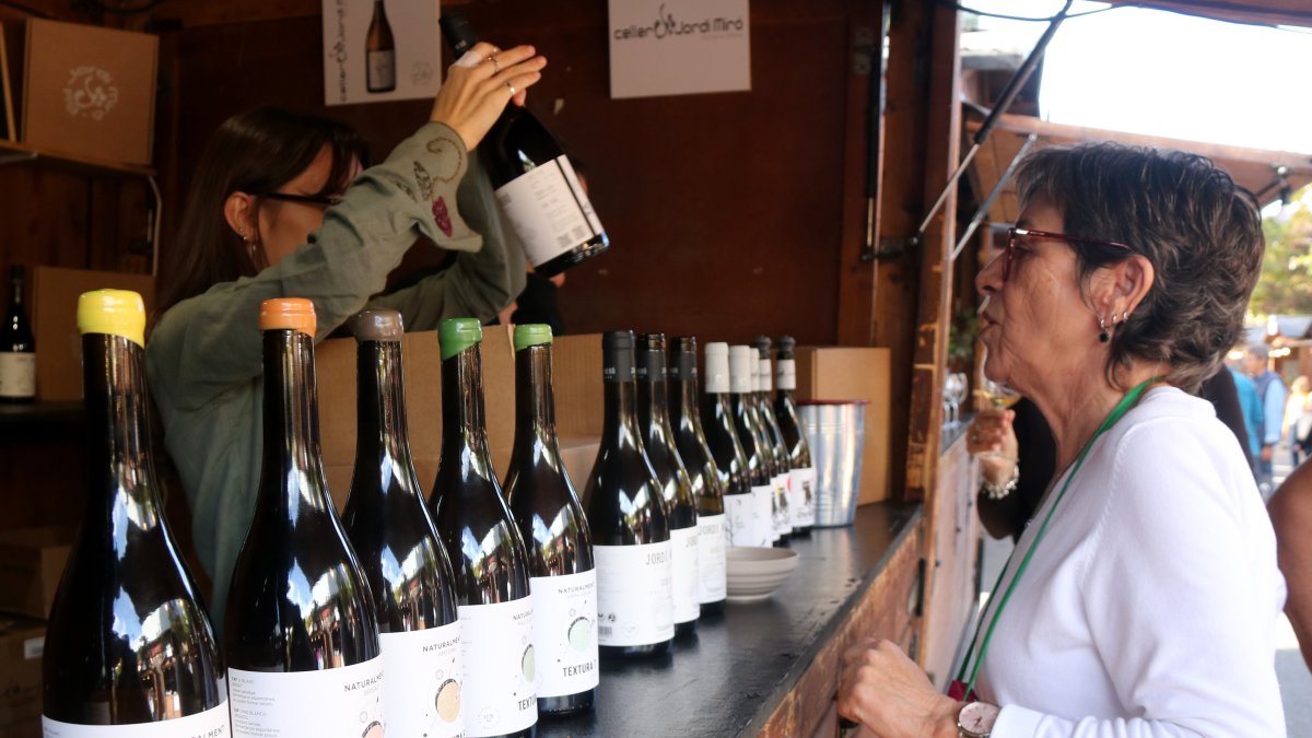 Una dona compra vi en una de les casetes de la 38a festa del Vi de Gandesa