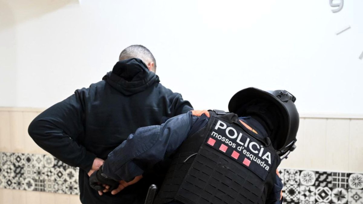 Un mosso d'esquadra escorcolla un individu en un bar del Vendrell.