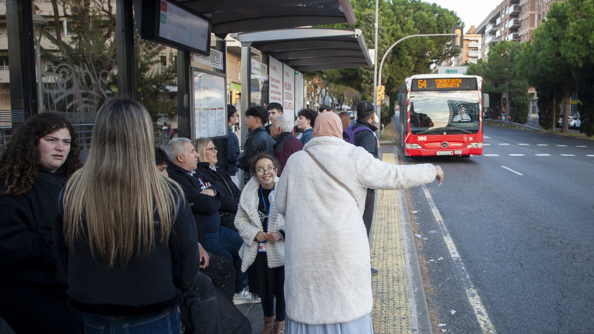 Imatge de diverses persones esperant el 54 a l'avinguda Roma.