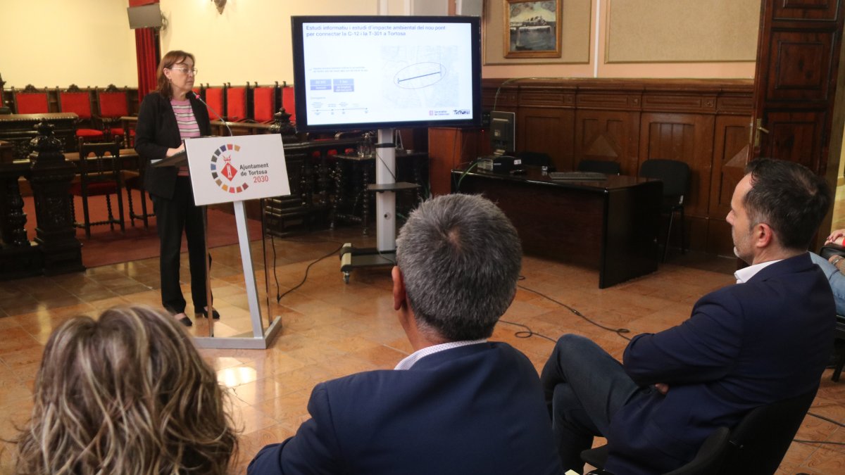 La consellera de Territori, Sílvia Paneque, durant la presentació del nou pont sobre l'Ebre amb l'alcalde de Tortosa, Jordi Jordan, escotant, a la dreta