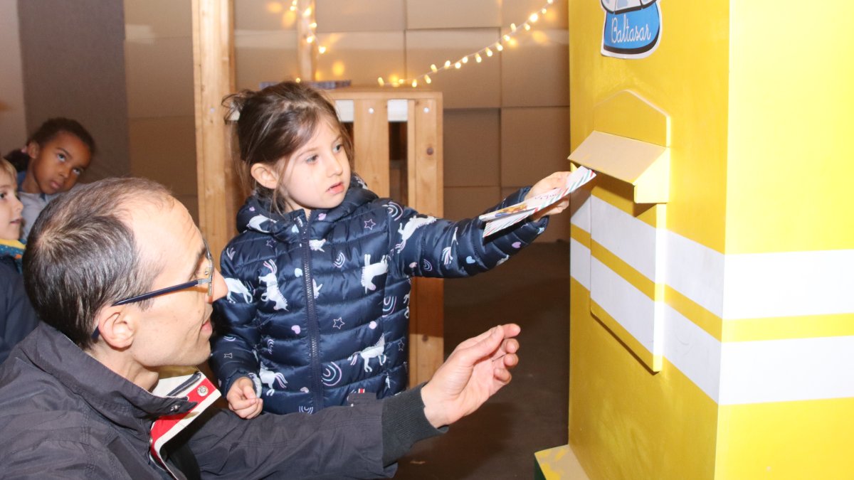 Una niña deposita su carta en el Buzón Real