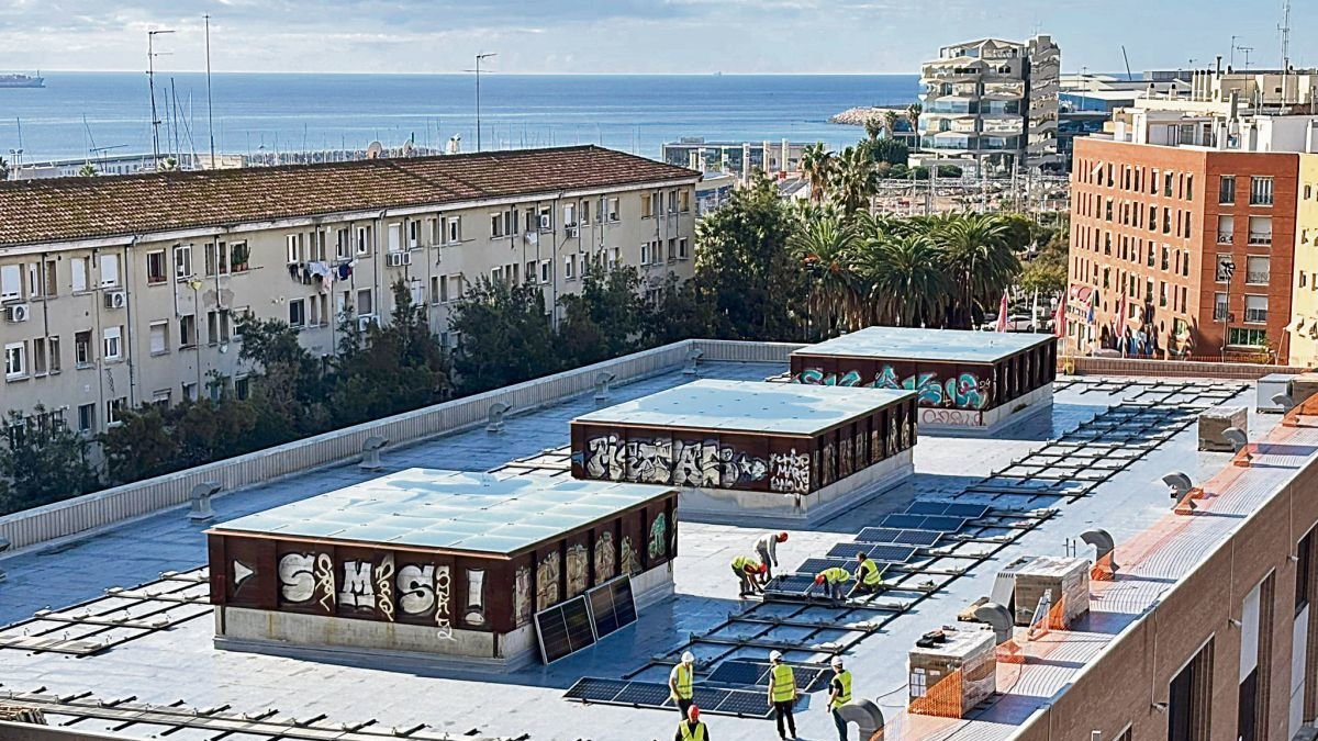 Imagen de los operarios instalando las placas solares en la cubierta del Palau Firal.