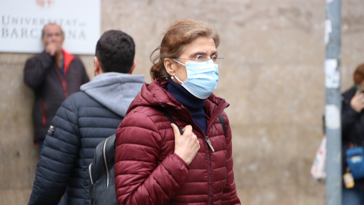 Una mujer saliendo del hospital Clínic con la mascarilla puesta.