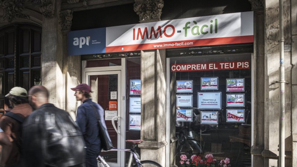Fachada de una inmobiliaria donde anuncian que compran pisos