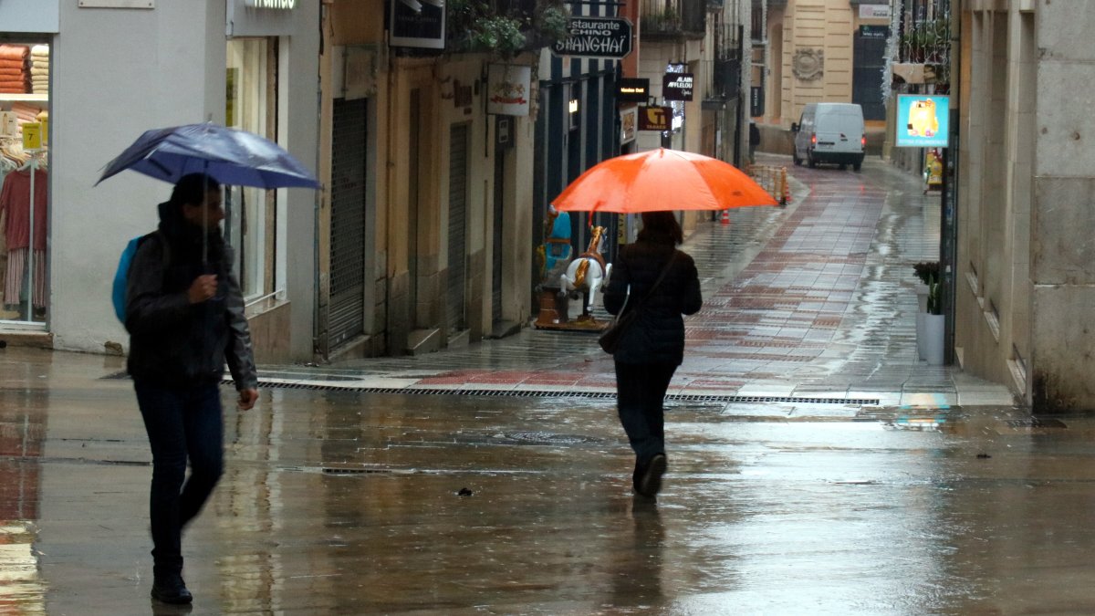 Imagen de dos personas con paraguas.