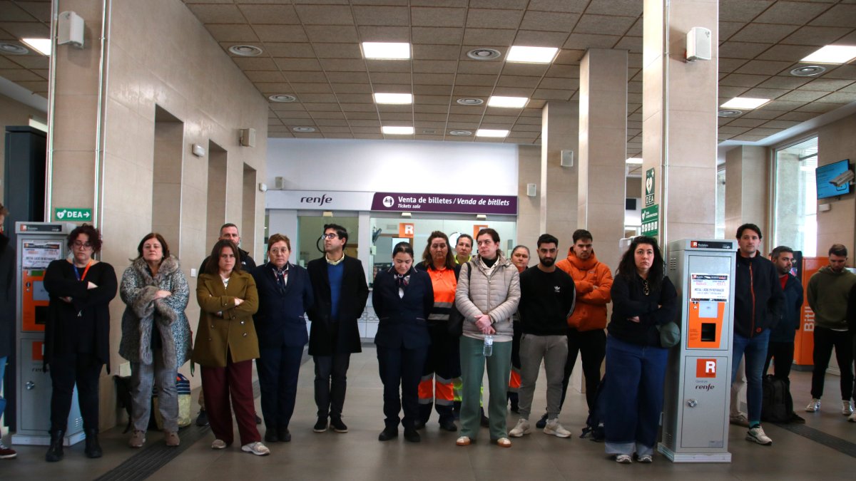 Treballadors de Renfe participant en els cinc minuts de silenci fets al vestíbul de l'estació de Tarragona.