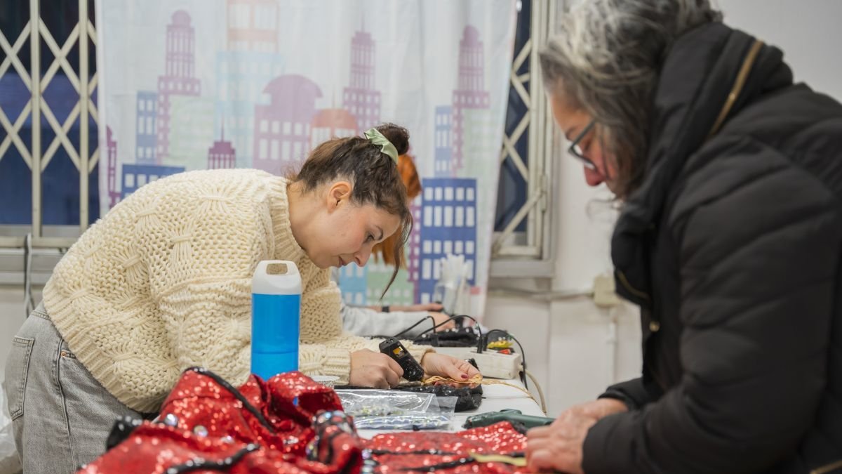 Imagen del taller de costura de la comparsa Urban Style, donde se acaban de confeccionar los últimos disfraces.  Una de las integrantes se prueba su disfraz mientras se hacen los últimos retoques.