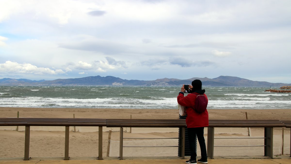Un home fa una foto al mar de l'Escala