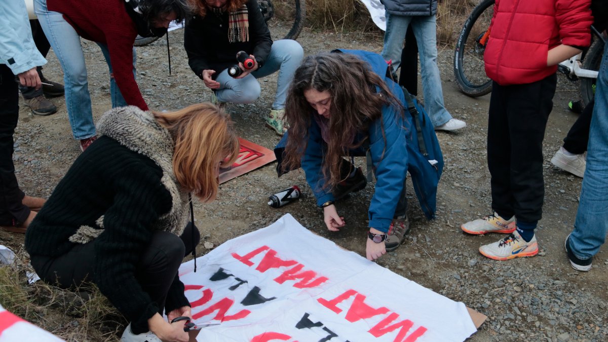 Dos mujeres elaboran pancartas en contra del proyecto de la MAT entre Aragón y Cataluña en un acto celebrado en Almoster.