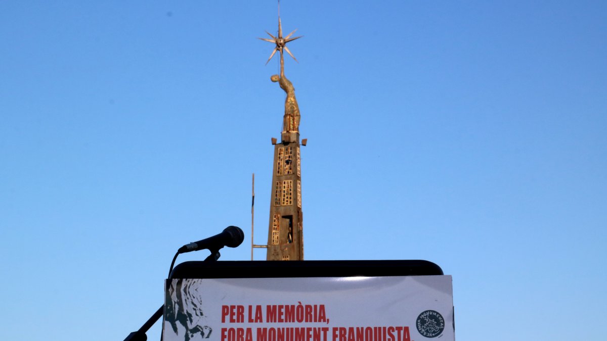 El monumento franquista de Tortosa detrás de una pancarta para su desmantelamiento.