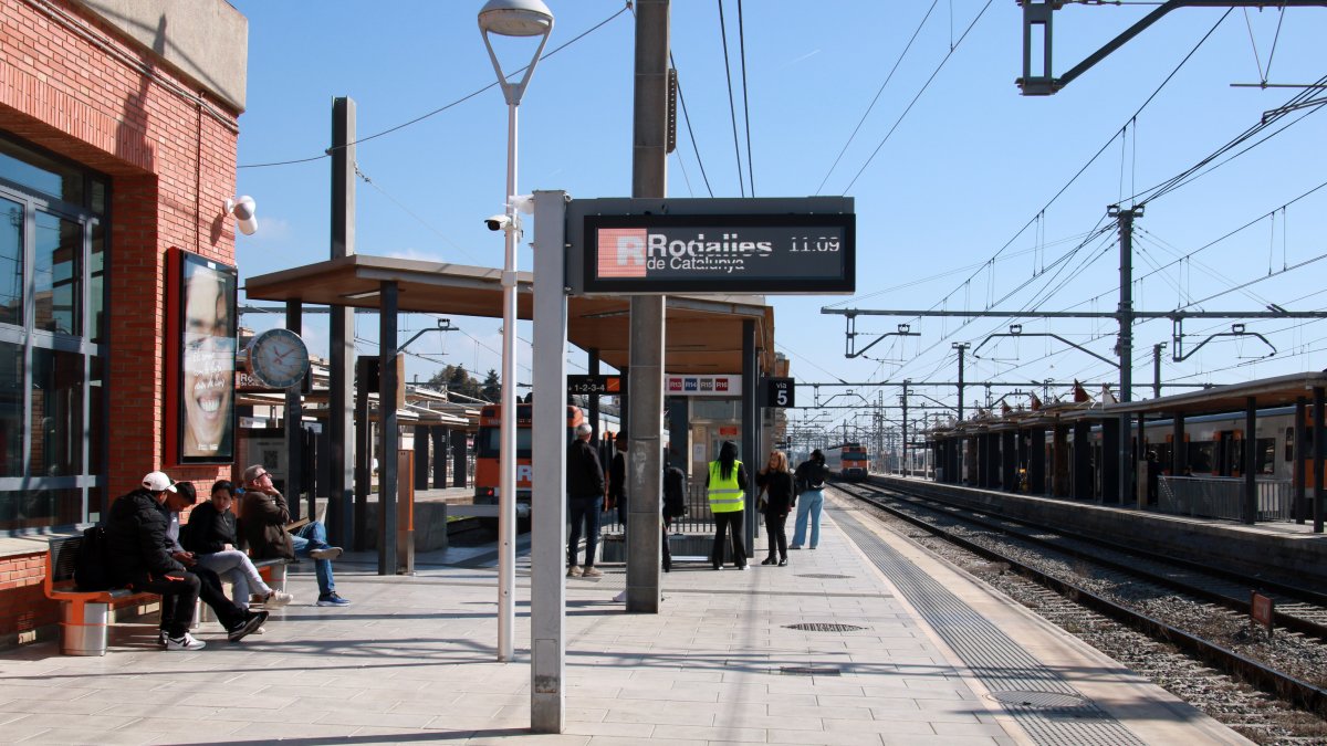 Varios usuarios esperando el tren en la estación de Sant Vicenç de Calders.