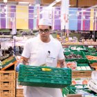Un noi treballant en un supermercat.