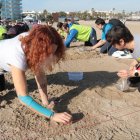Dues dones participen a l'acció de mostreig de pèl·lets a la platja del Racó de Salou.