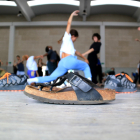 Primer pla d'unes sabates davant d'un grup de ballarins fan classe a Deltebre Dansa.