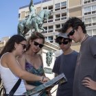 La guia, explicant a la família madrilenya quins són els punts més destacats del mapa de la ciutat.