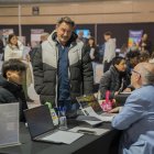 Fotografia d’un expositor de la Jornada Treballa al Turisme atenent a un visitant.