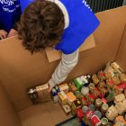 Un voluntari col·loca els aliments recollits.