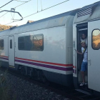 Usuaris d'un tren aturat entre Flix i Móra per una avaria d'electrificació a la línia esperen que els vinguin a rescatar per poder continuar el viatge el 18 de juliol del 2016. Pla general