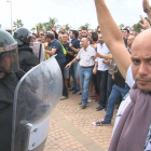 Gente con las manos en alto delante de los antidisturbios de la Guardia Civil en la Ràpita, este 1 de octubre de 2017