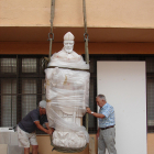 Gallart i un ajudant, col·locant l'escultura al pati de la casa.