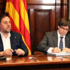 El vicepresidente Oriol Junqueras observa al presidente de la Generalitat, Carles Puigdemont, firmando, el 6 de septiembre de 2017