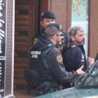 Dos agentes de la Guardia Civil se llevan a un detenido en Sabadell en el marco de la operación que ha acabado con nueve miembros de CDR arrestados.