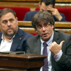 Carles Puigdemont i Oriol Junuers durant el debat parlamentari d'aquest dijous.