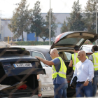Agentes de la Guardia Civil poniendo mochilas en los maleteros de los coches en la salida de la imprenta de Constantí.