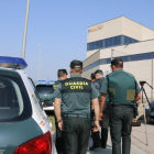 Agentes de la Guardia Civil, de espalda, delante de las puertas de las instalaciones de la imprenta de Constantí.